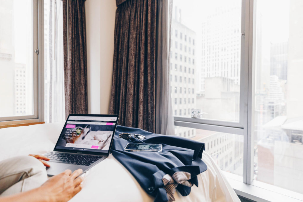 Woman working on laptop in hotel room at club quarters with a view